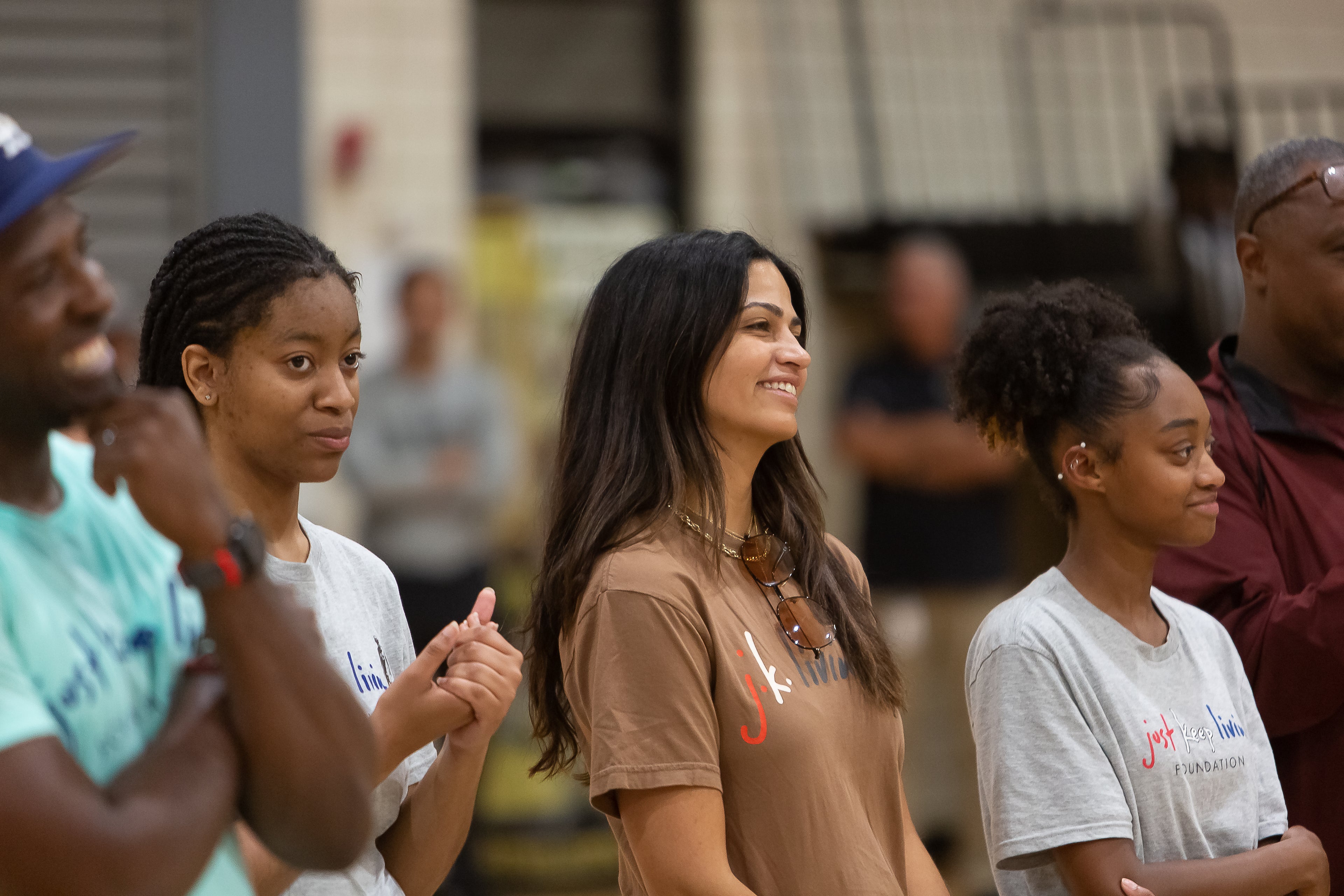 Camila McConaughey at at Just Keep Livin event with students in a school gym. 
