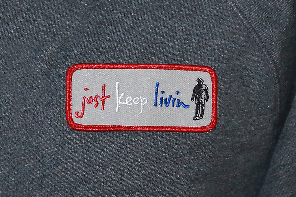 Just Keep Living Logo close up of patch on gray hoodie breast. 