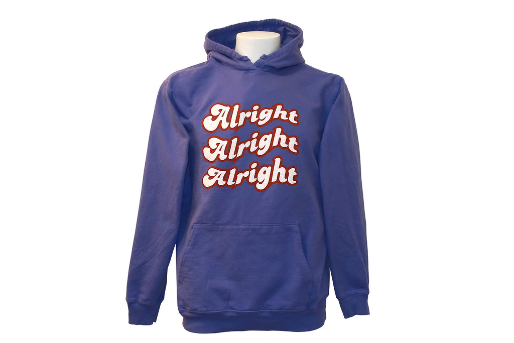 Purple hoodie with alright alright alright white text with red outline. 