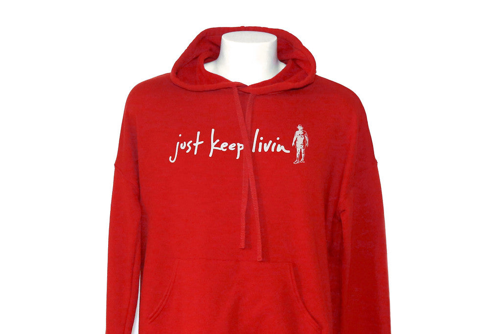 A red hoodie with the text 'just keep livin' printed on the front in white, displayed on a mannequin.