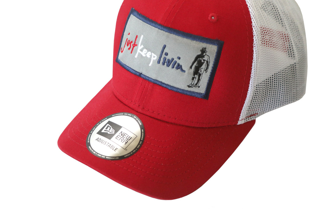 A red and white structured cap with a snapback design and an embroidered patch on the front featuring text and a graphic.